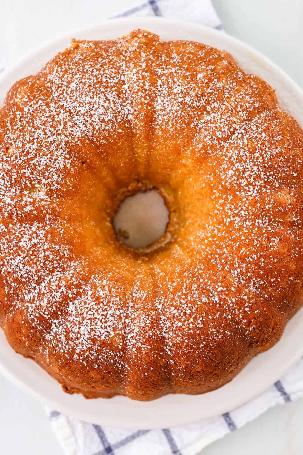overhead view of cream cheese bundt cake made with a mix, served on a white platter.
