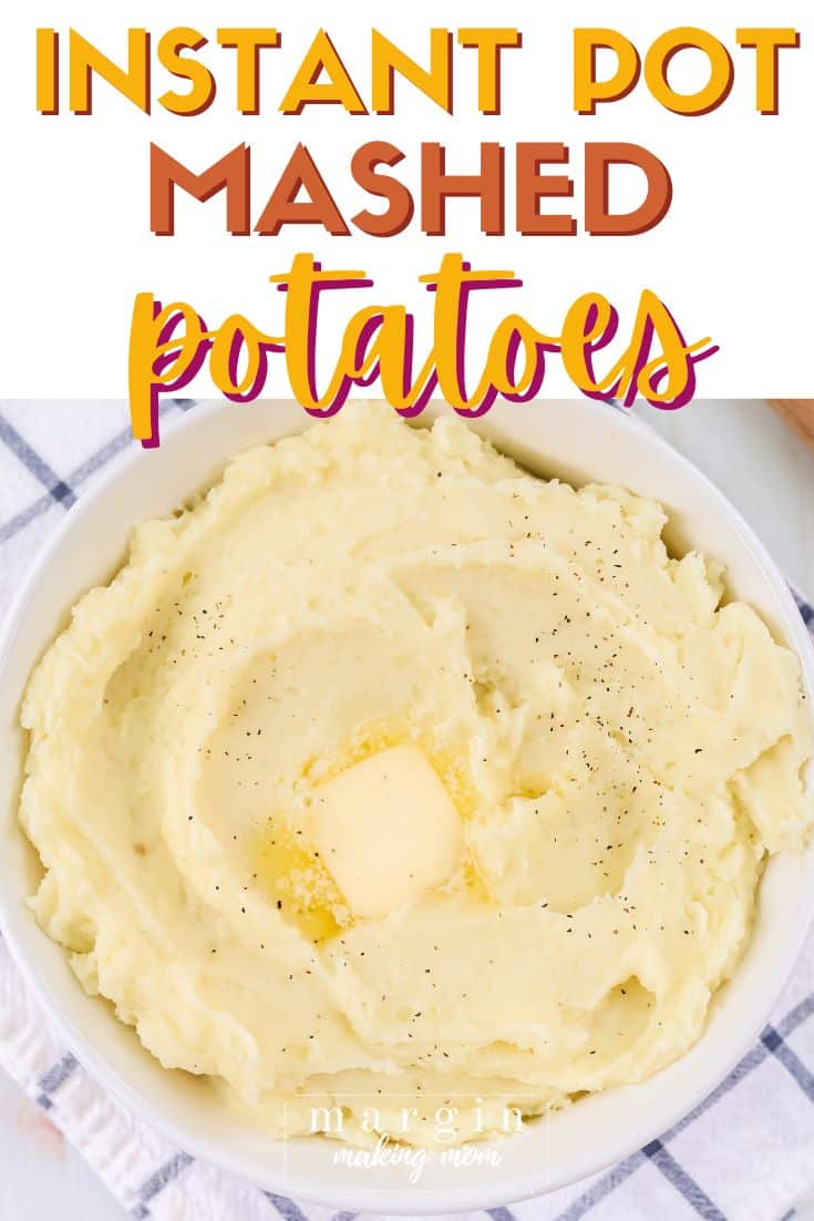overhead view of a white serving bowl filled with instant pot mashed potatoes, topped with a pat of butter.
