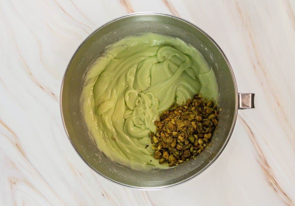 chopped pistachios added to cake batter in mixing bowl.