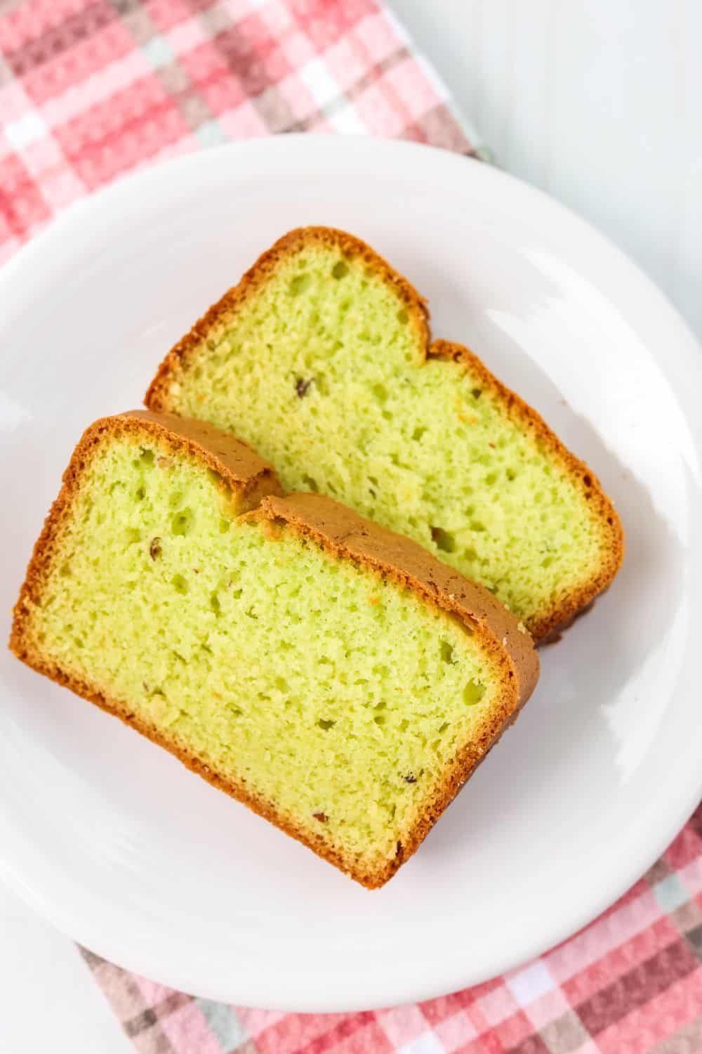 two slices of holiday pistachio bread on a white plate
