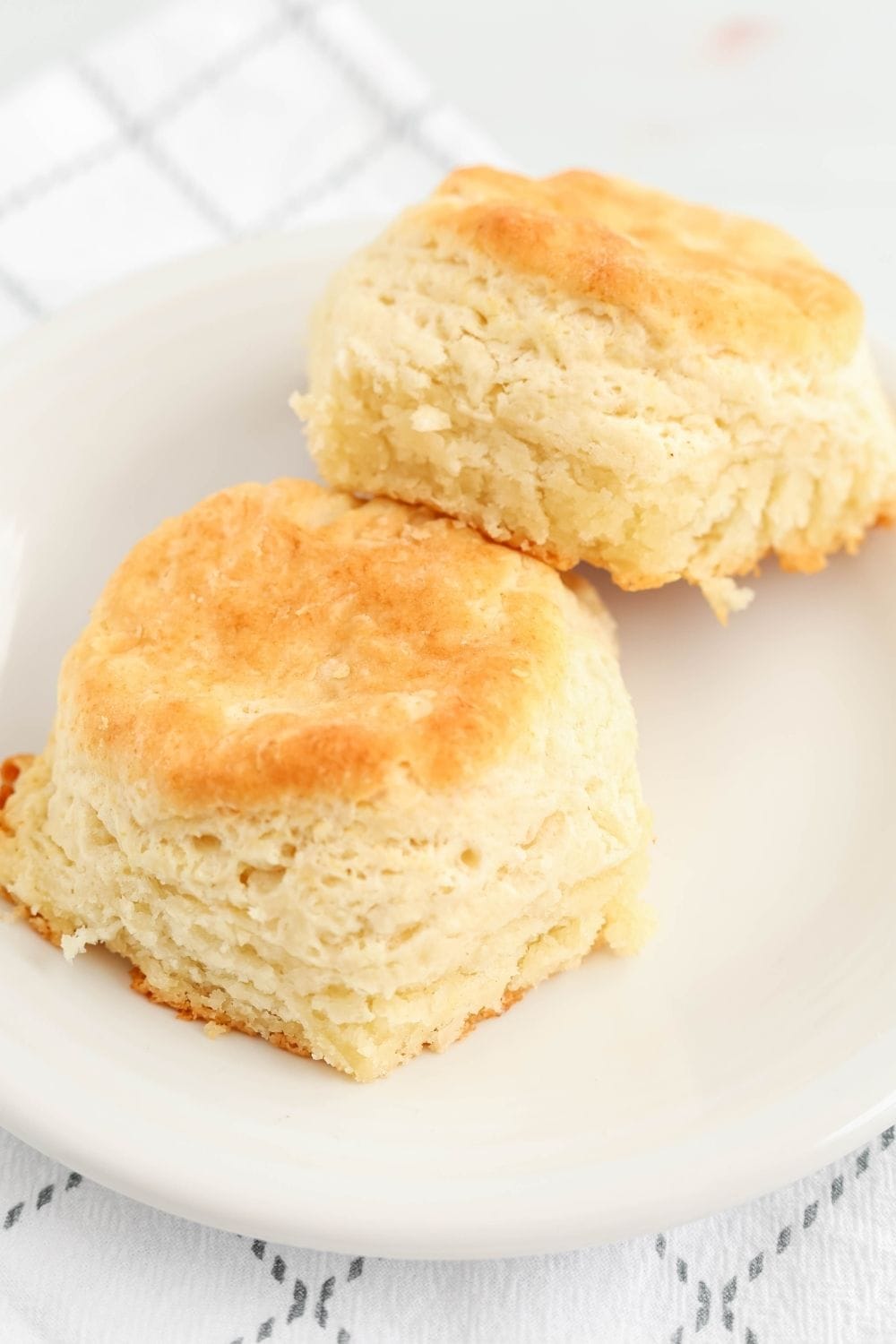 two cut and rolled Bisquick biscuits, freshly baked and served on a white plate.