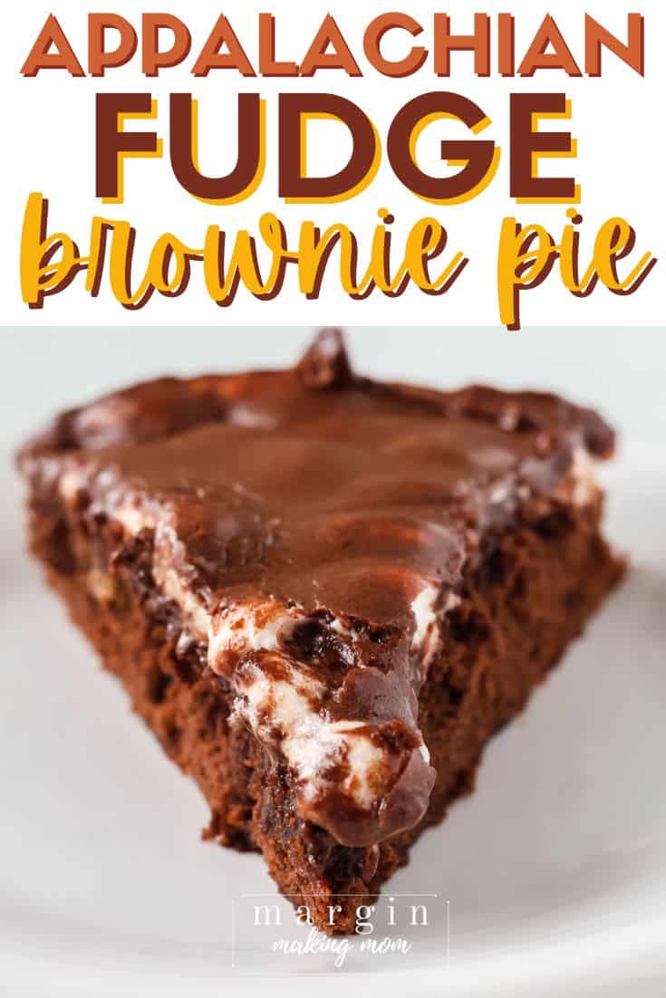 close-up view of a slice of Appalachian fudge brownie pie, showing the brownie base, melty marshmallow layer, and chocolate frosting on top.
