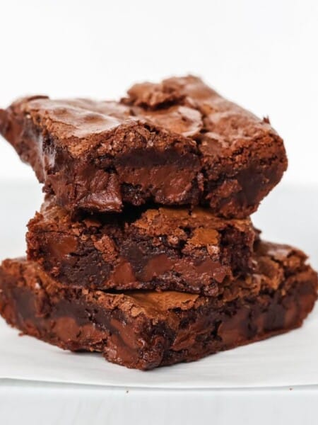 three Bisquick brownies stacked on top of each other on a piece of parchment paper