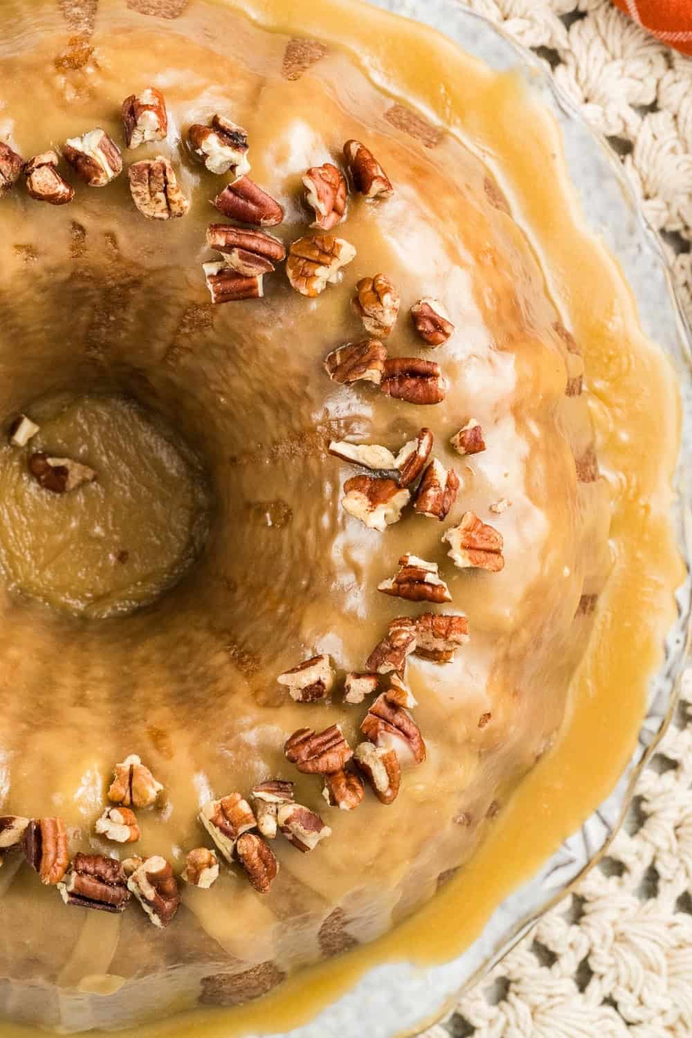 close-up overhead view of glazed sweet potato pound cake with pecans sprinkled on top.