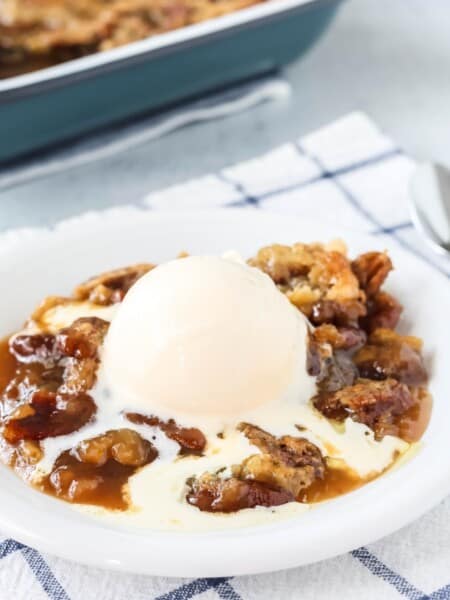a serving of pecan cobbler made with Bisquick is topped with vanilla ice cream.