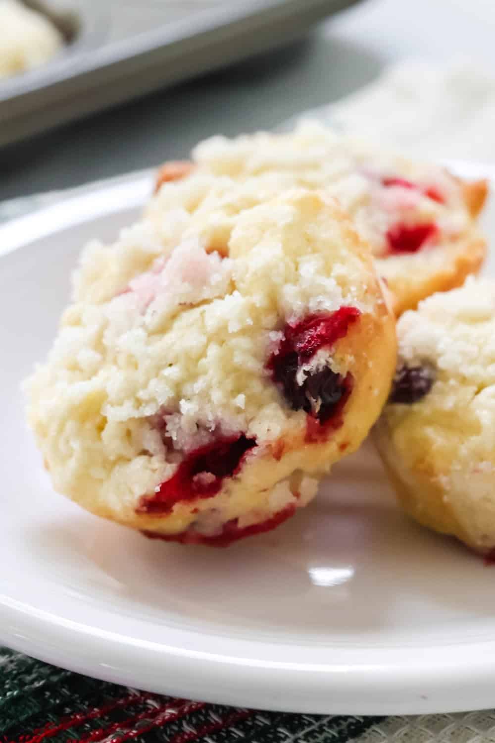 close-up view of a cream cheese cranberry muffin, showing the juicy cranberries studded throughout, as well as the crunchy streusel topping.