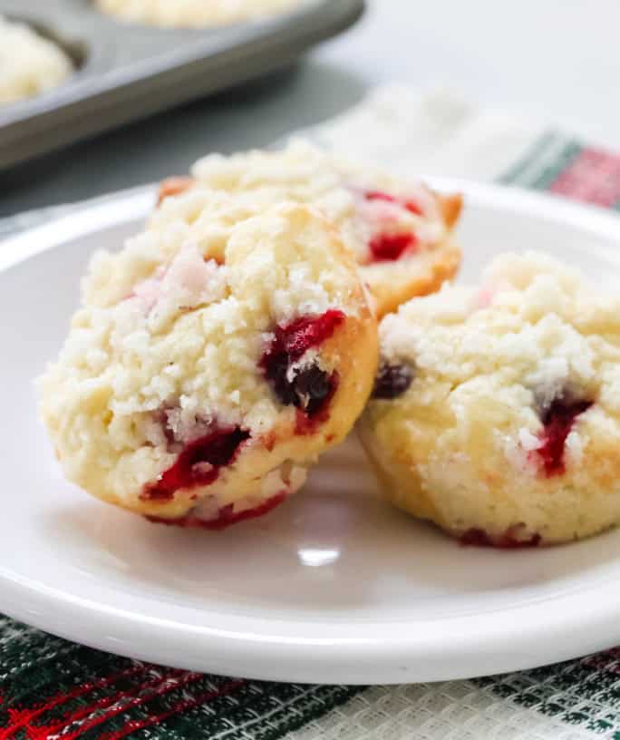 Cream cheese cranberry muffins served on a white plate.