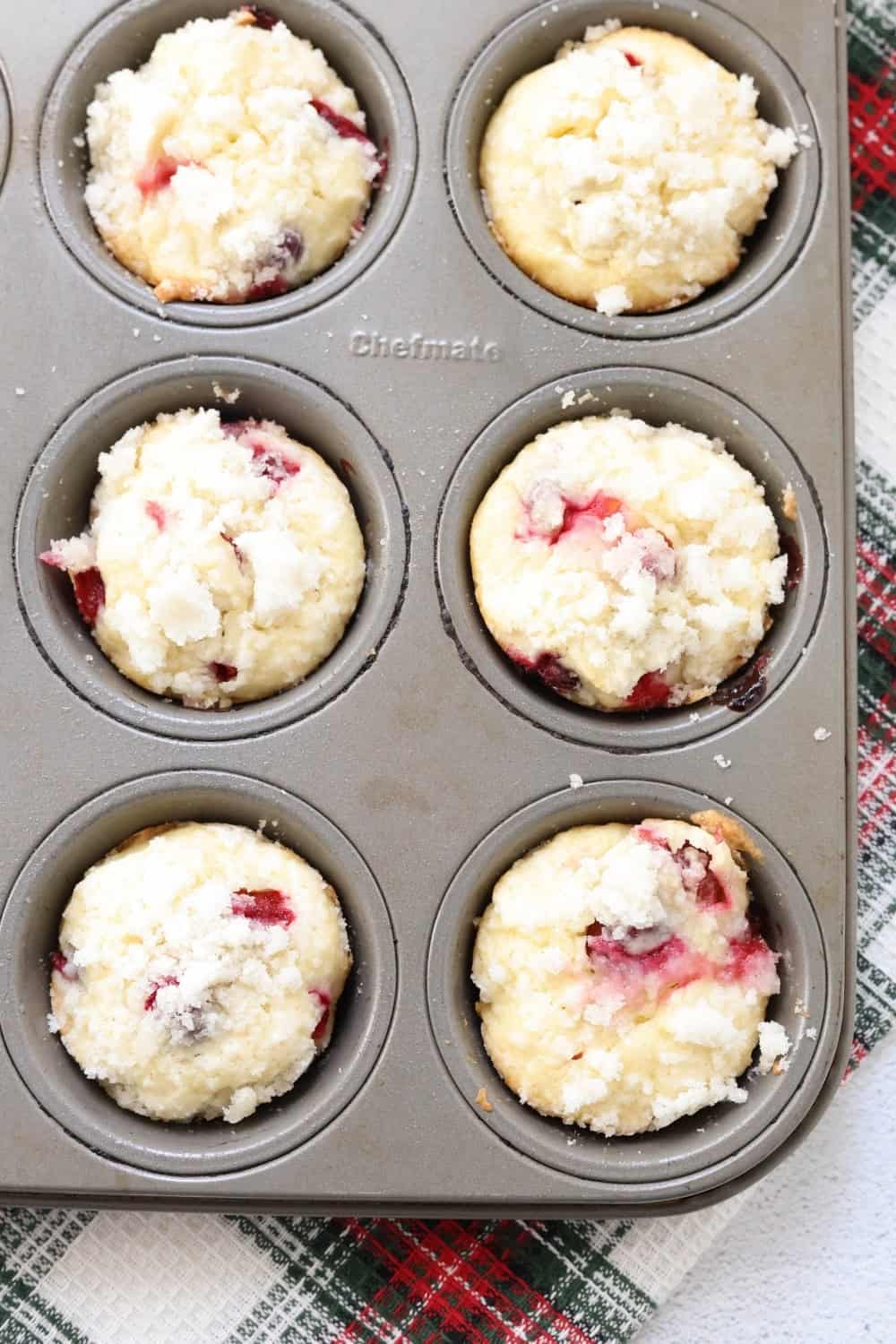 overhead view of a muffin pan of freshly baked cranberry streusel muffins made with cream cheese.
