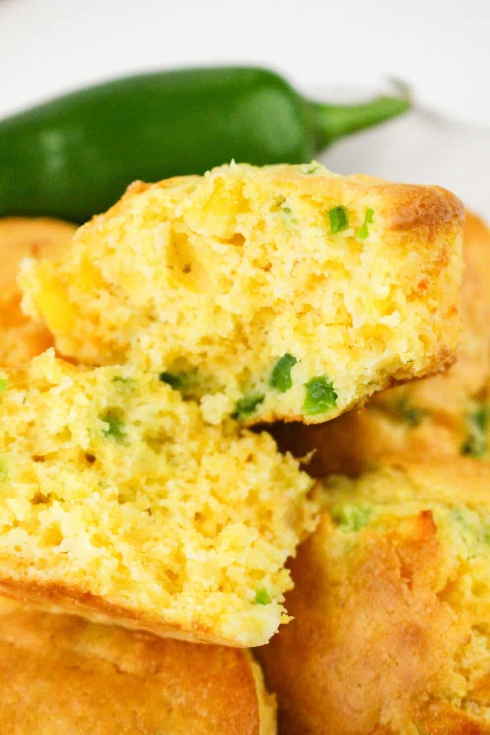 jalapeno corn muffin made with Jiffy mix, split open to reveal the soft and tender interior with flecks of green peppers.