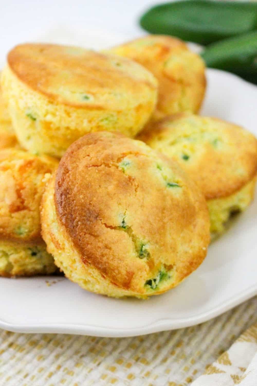 cornbread muffins with corn, cheese, and jalapenos served on a white plate.