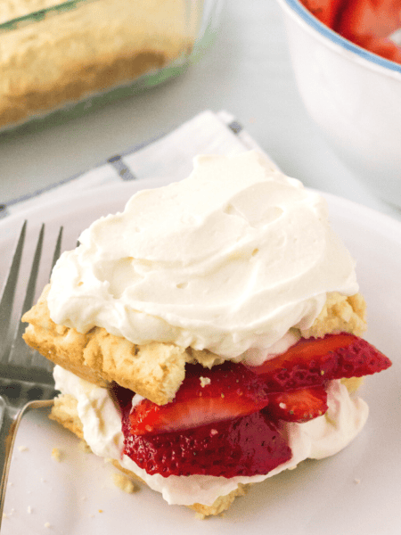 old-fashioned strawberry shortcake, made from scratch, served on a white plate with a fork.