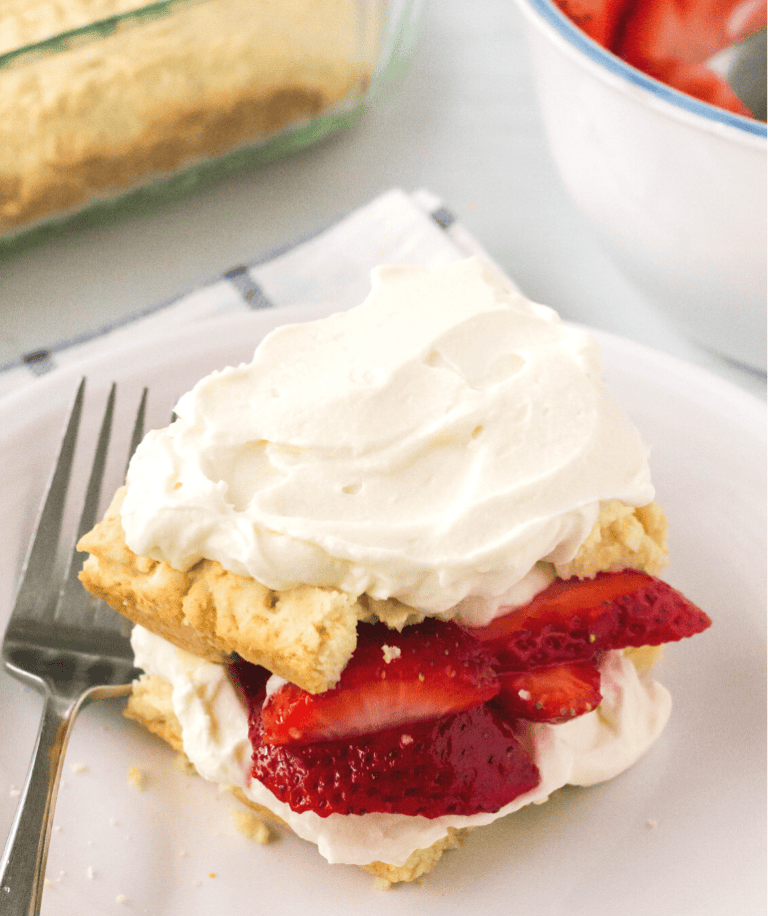 old-fashioned strawberry shortcake, made from scratch, served on a white plate with a fork.