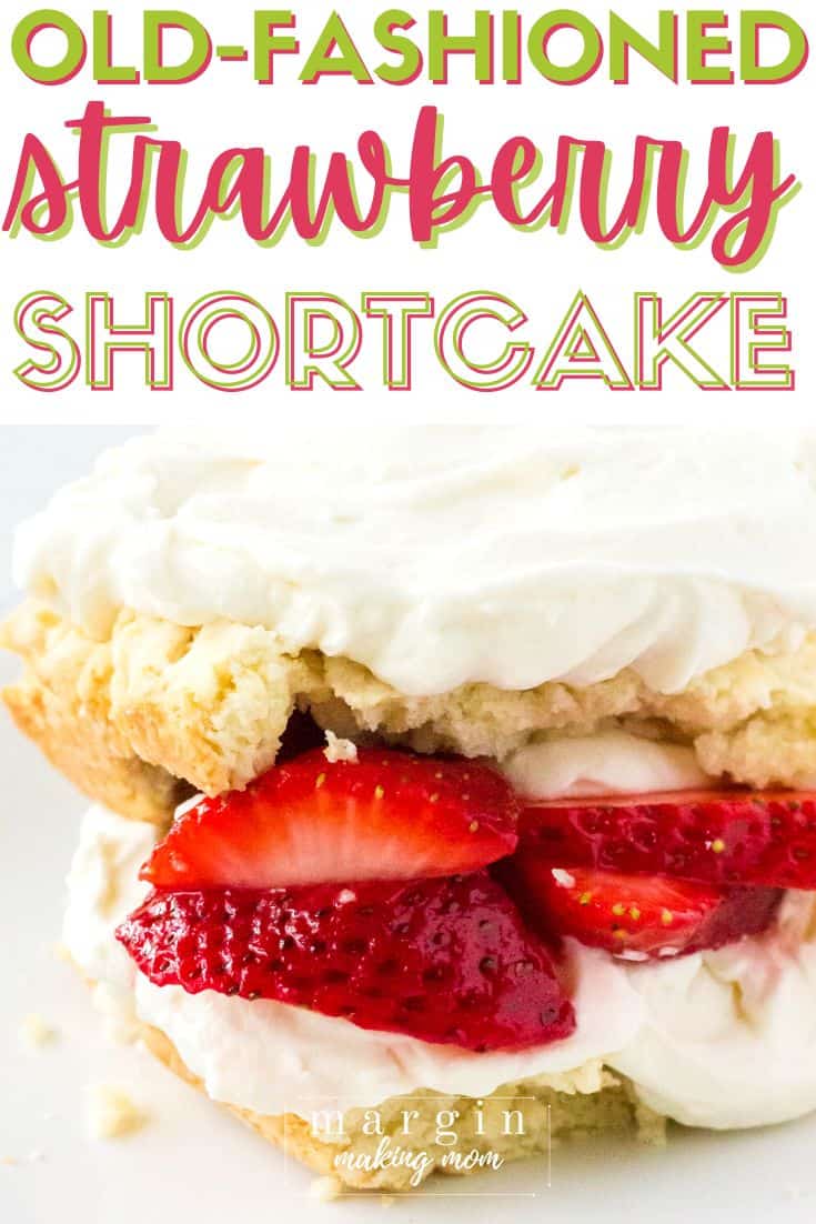 close-up view of homemade strawberry shortcake, with two layers of biscuit-like shortcake filled with whipped cream and juicy strawberries.
