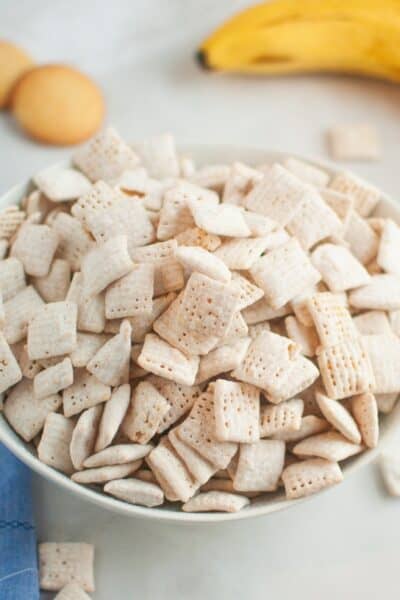 banana pudding Muddy Buddies snack mix served in a white bowl.