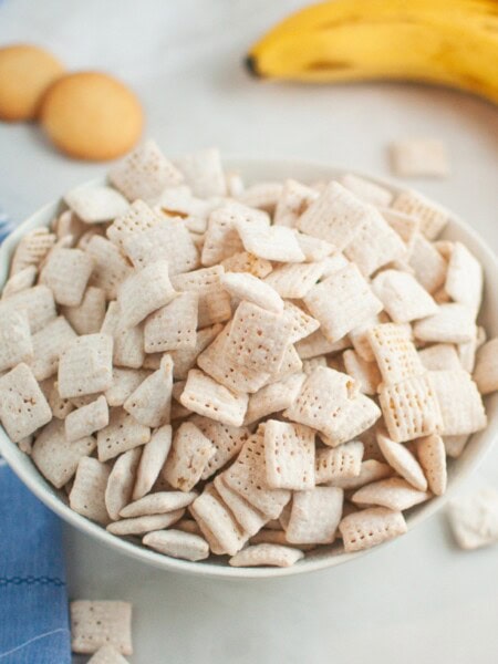 banana pudding Muddy Buddies snack mix served in a white bowl.