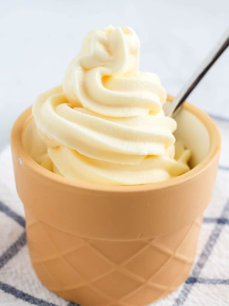 Ninja Creami Swirl vanilla soft serve ice cream in a dessert cup with a spoon.