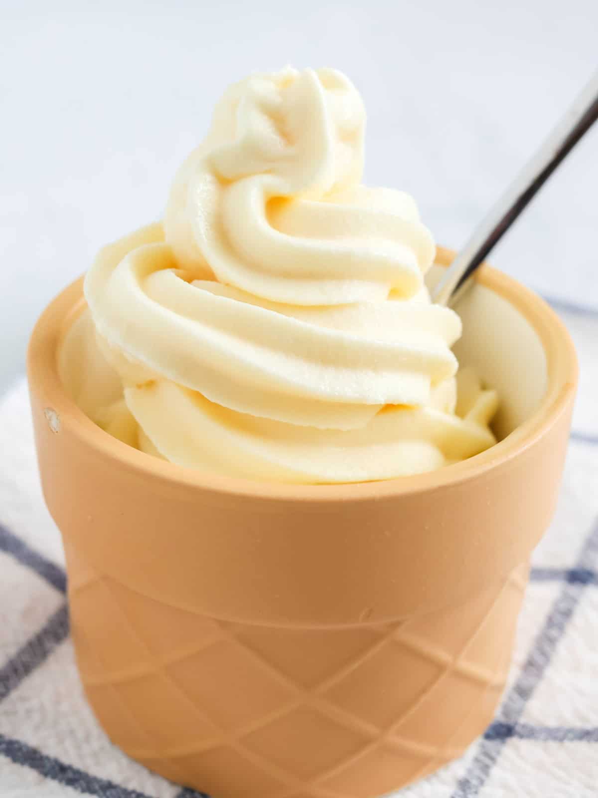 Ninja Creami Swirl vanilla soft serve ice cream in a dessert cup with a spoon.