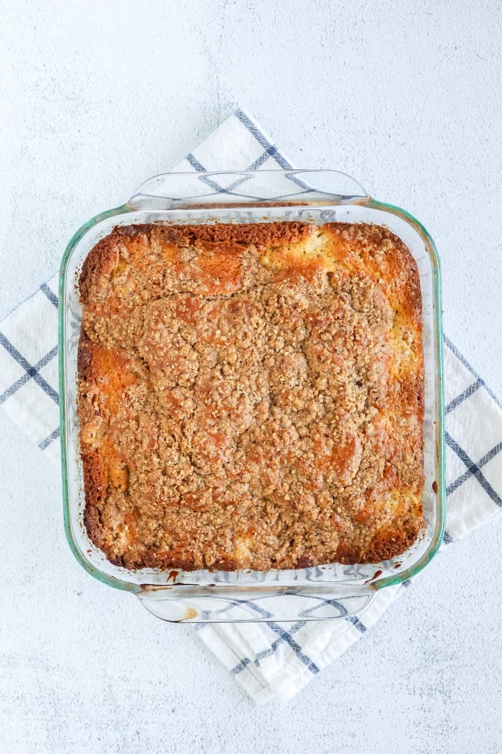 overhead view of a glass baking dish of freshly baked coffee cake made with fresh pears.