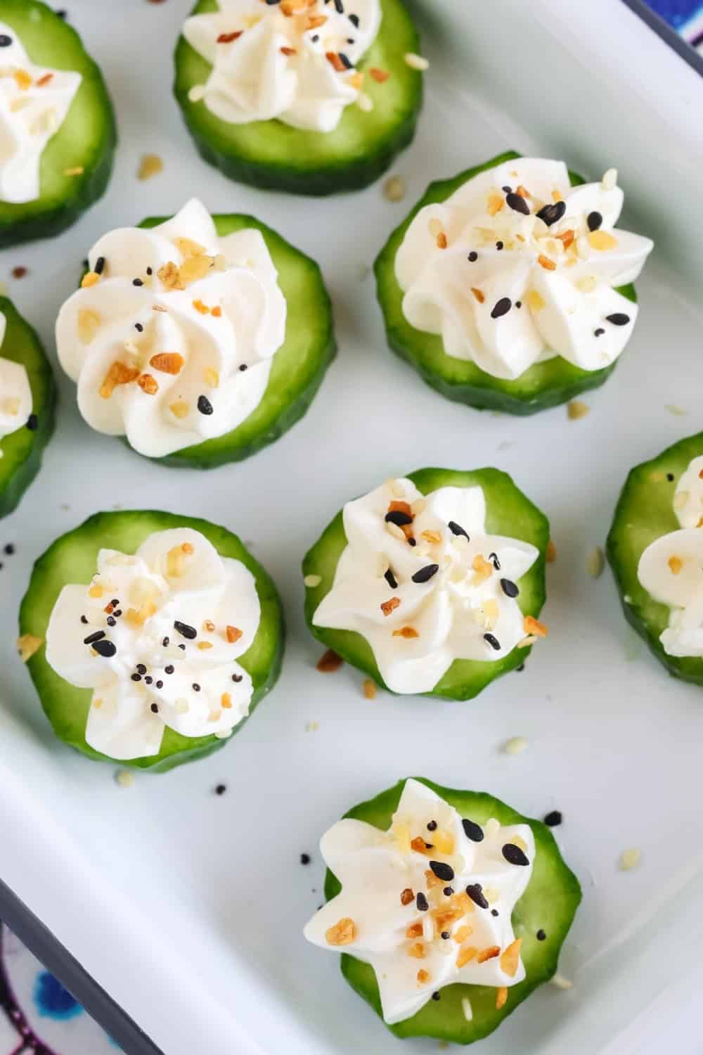 close-up view of cucumber slices topped with whipped cream cheese and everything bagel seasoning for an easy appetizer.