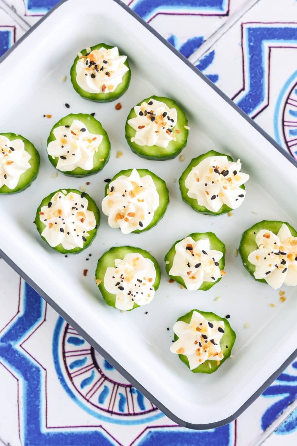 appetizer plate with cucumber everything bagel cream cheese bites on it.