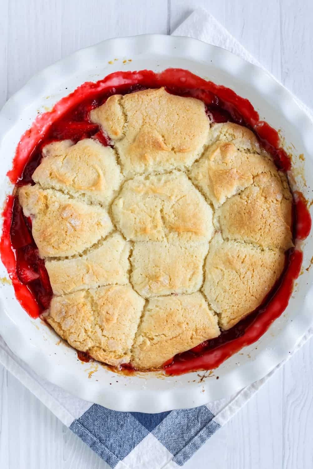 overhead view of a white pie pan of fresh strawberry Bisquick cobbler, shortly after removing from oven.