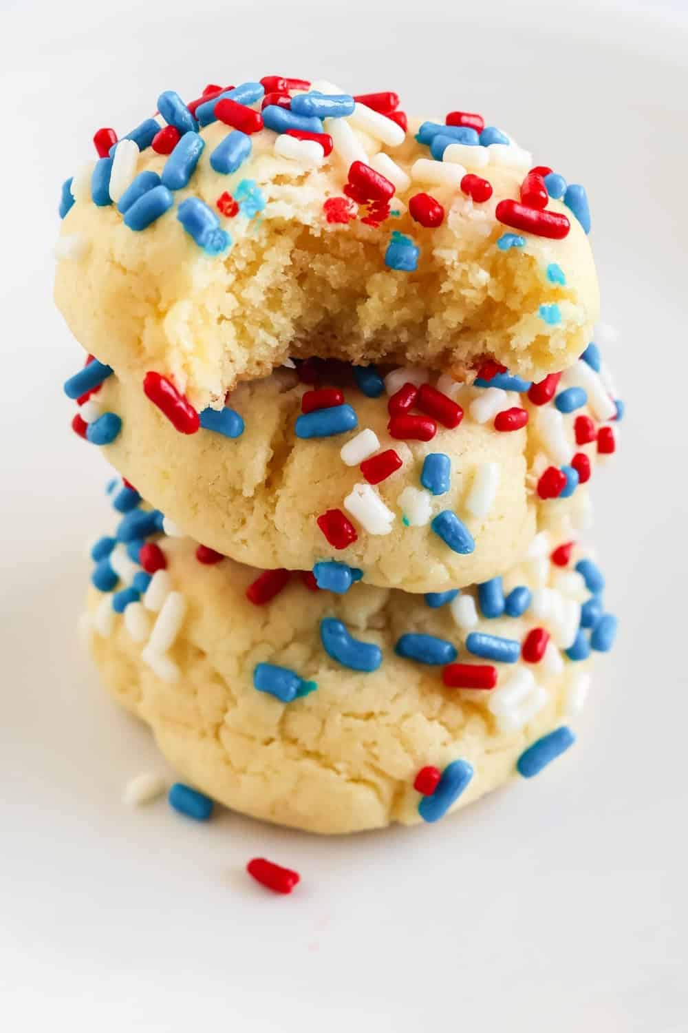 Three cookies made with cake mix are stacked together. The cookies are covered in 4th of July sprinkles, showing that this recipe can be used year-round for various holidays.