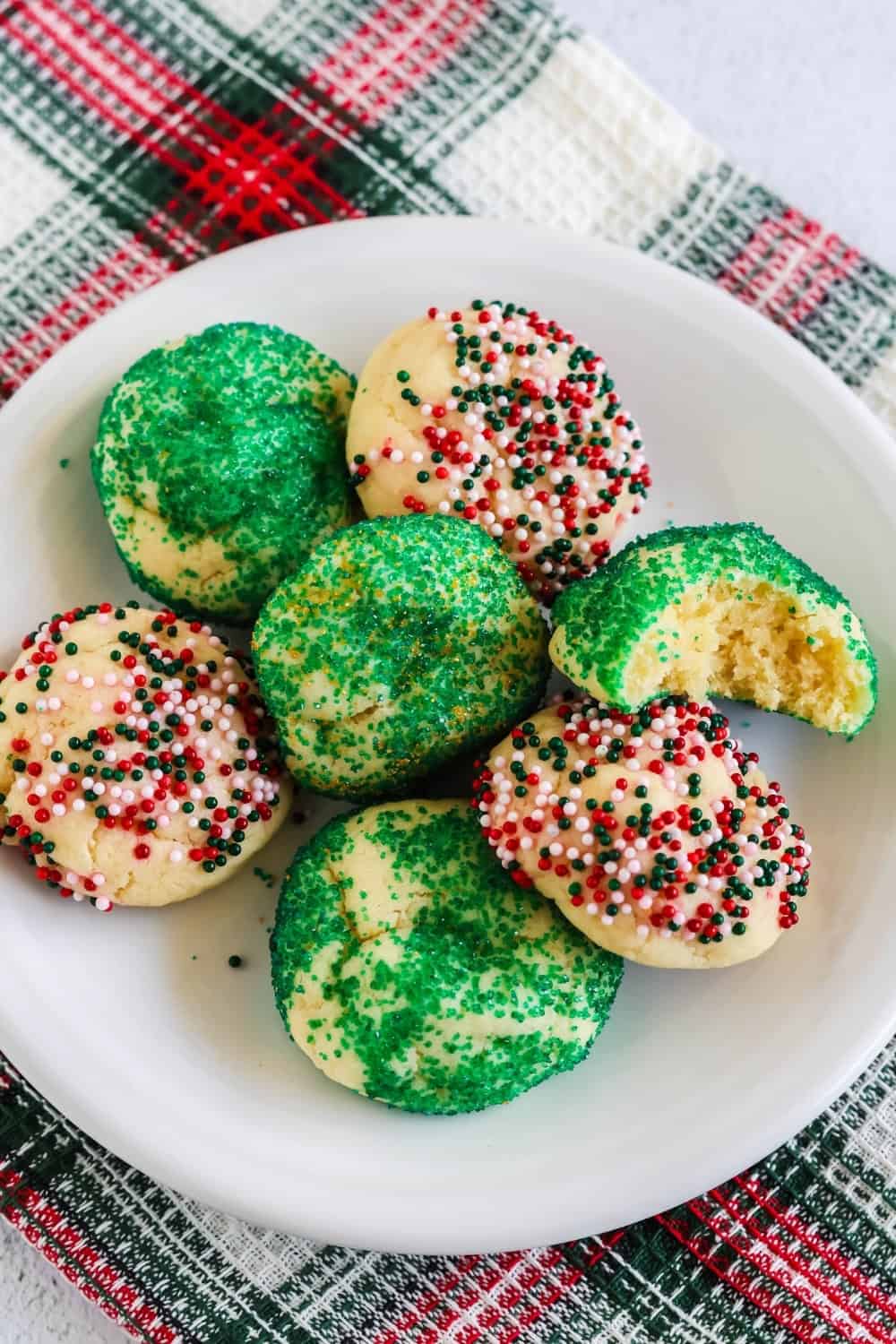 overhead view of a plate of holiday cake mix cookies that were rolled in colorful sprinkles and sanding sugar.