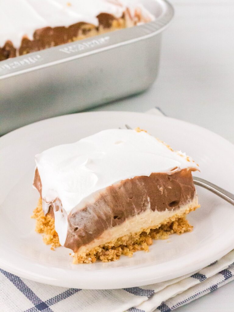 slice of chocolate peanut butter lush served on a white plate.