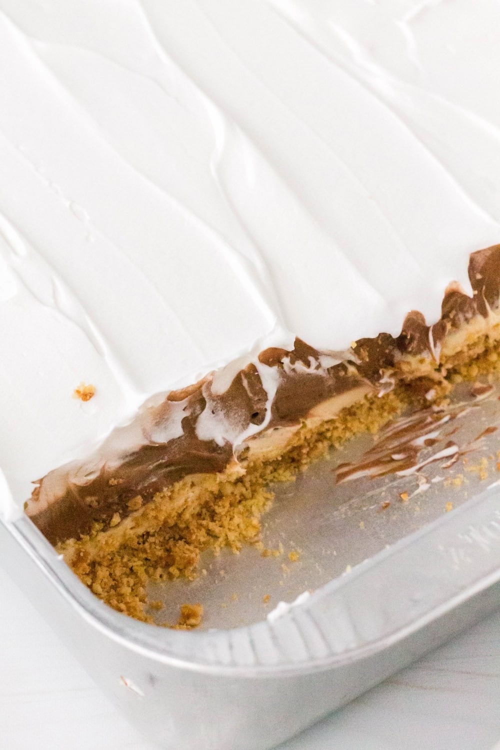pan of chocolate peanut butter lush with several slices removed.