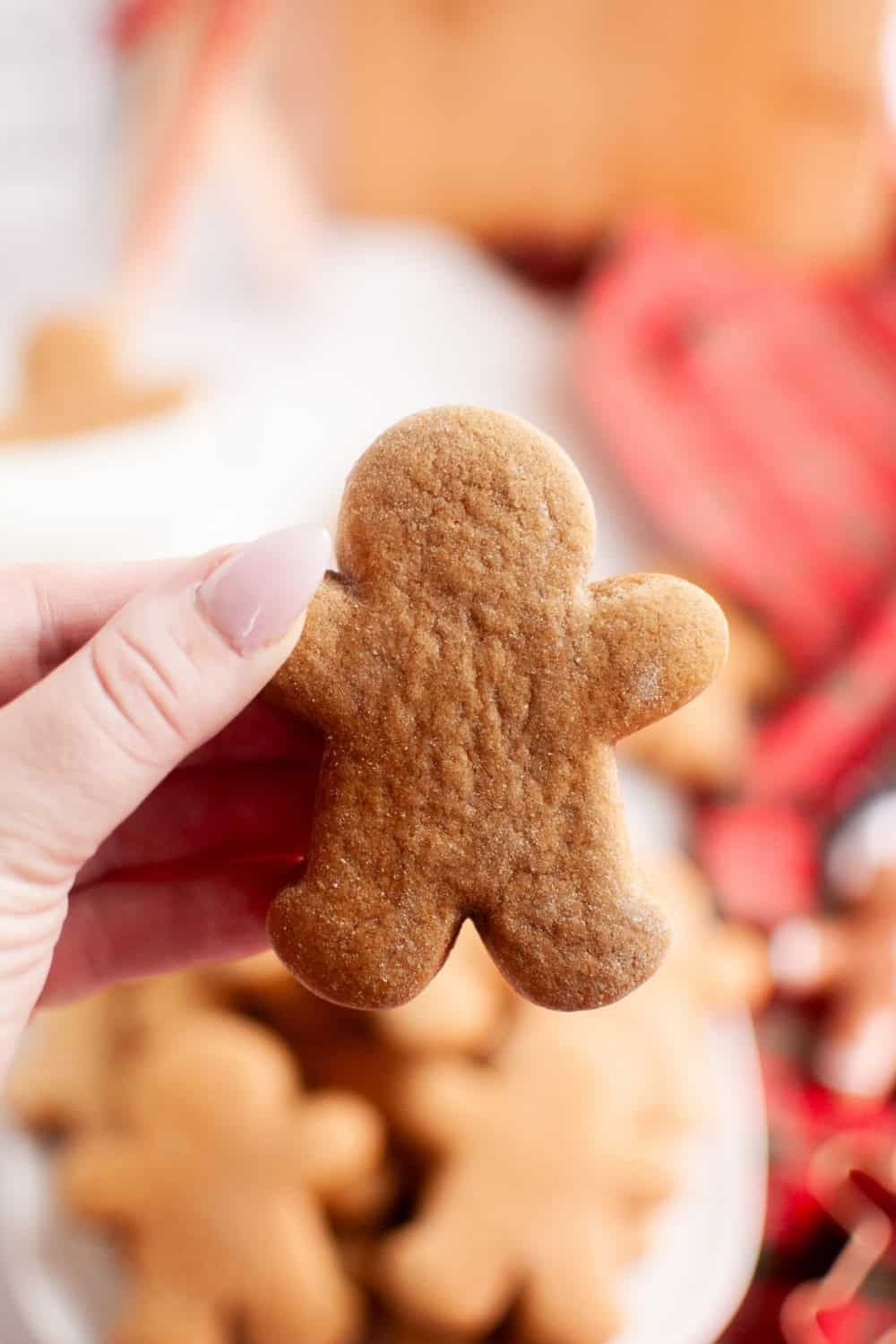 a woman's hand holds a gingerbread cookie that was made with a box of spice cake mix for Christmas.