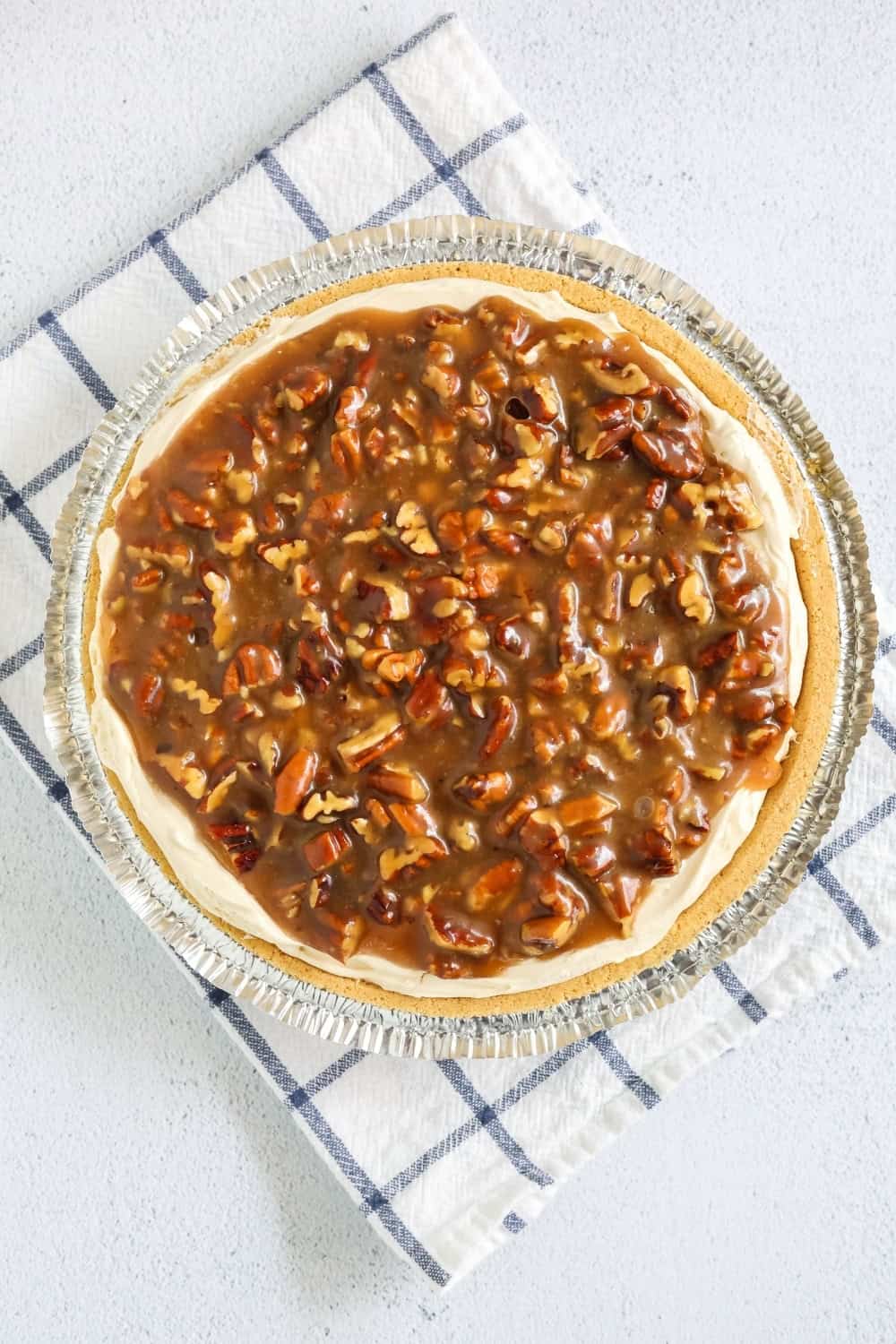 overhead view of a no bake pecan pie cheesecake after chilling, but  prior to being sliced.