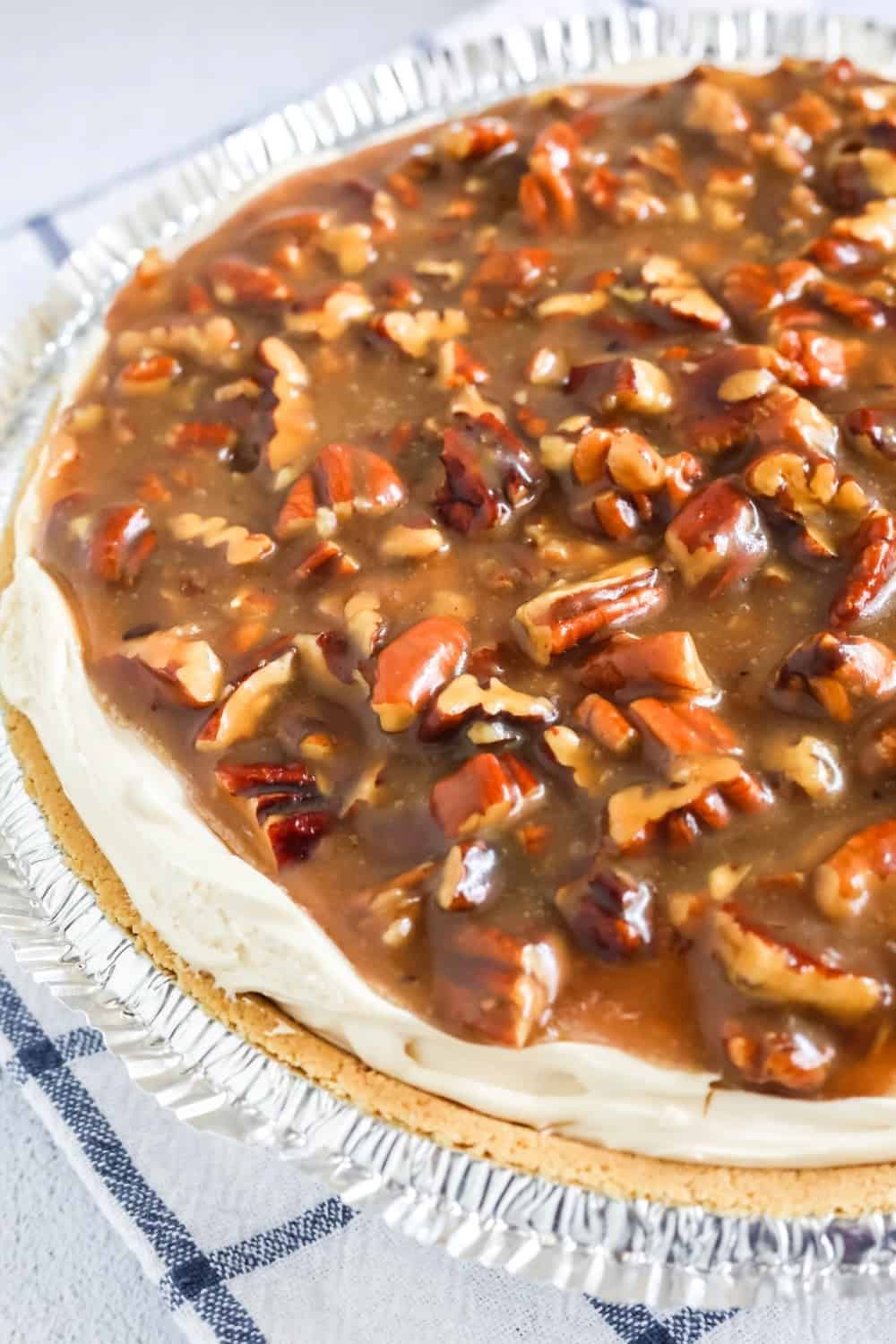 close-up side view of a no-bake pecan cheesecake, showing the creamy filling and the caramel-like topping.