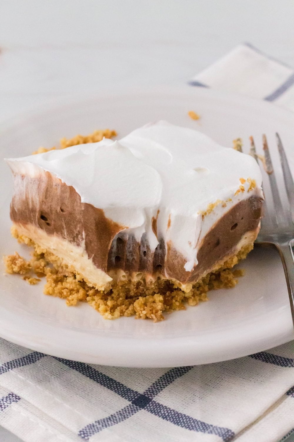 slice of peanut butter chocolate layered dessert with a bite taken out of it.