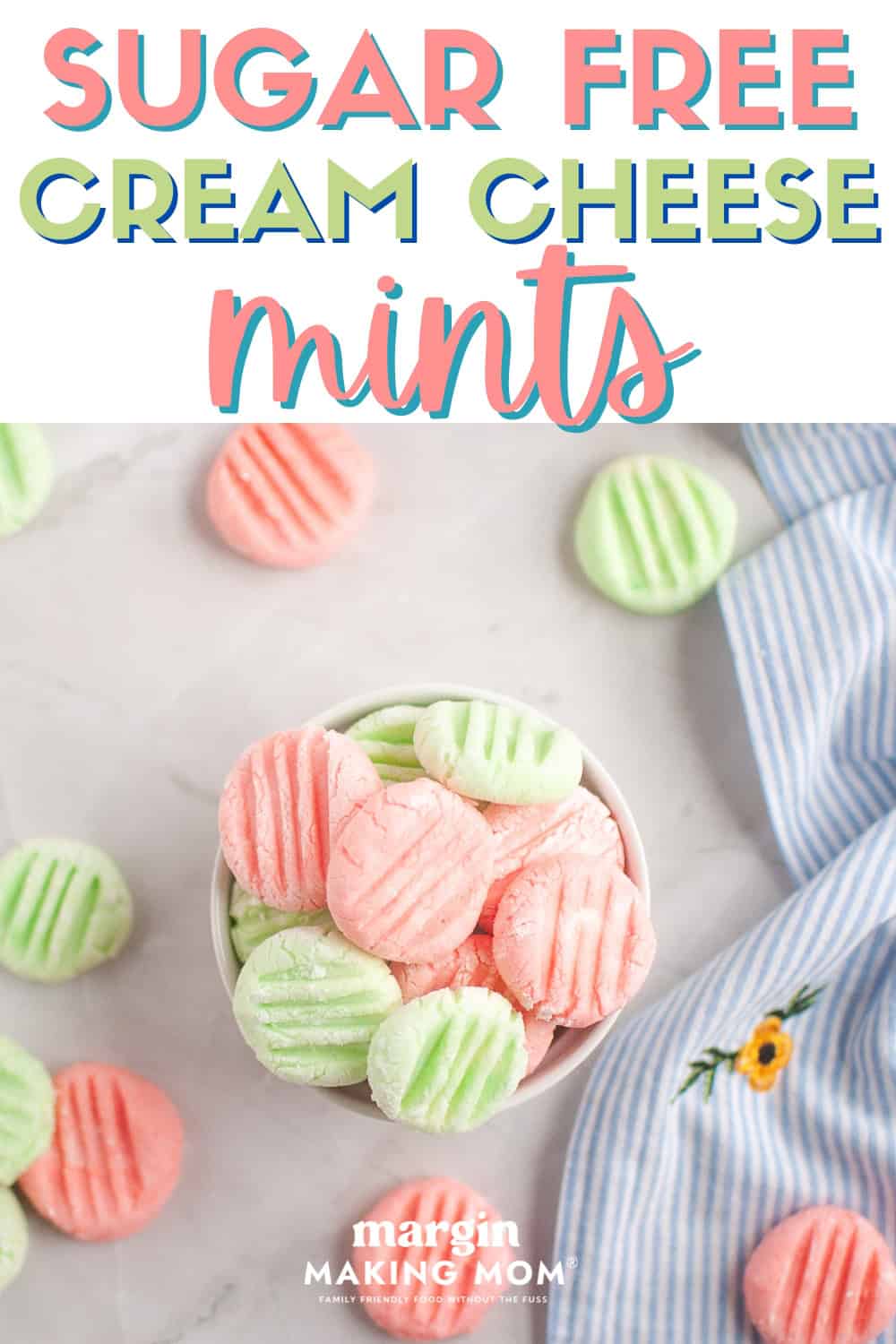 overhead view of pink and green sugar-free cream cheese mints in a white bowl, with several scattered around.