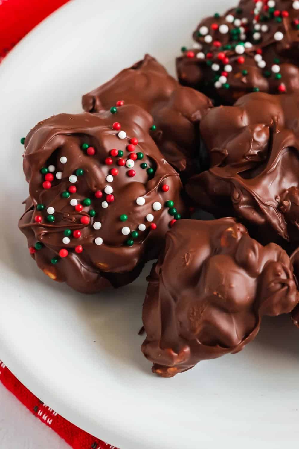 close-up view of chocolate peanut clusters that are sugar-free. Some are topped with Christmas non-pareils.