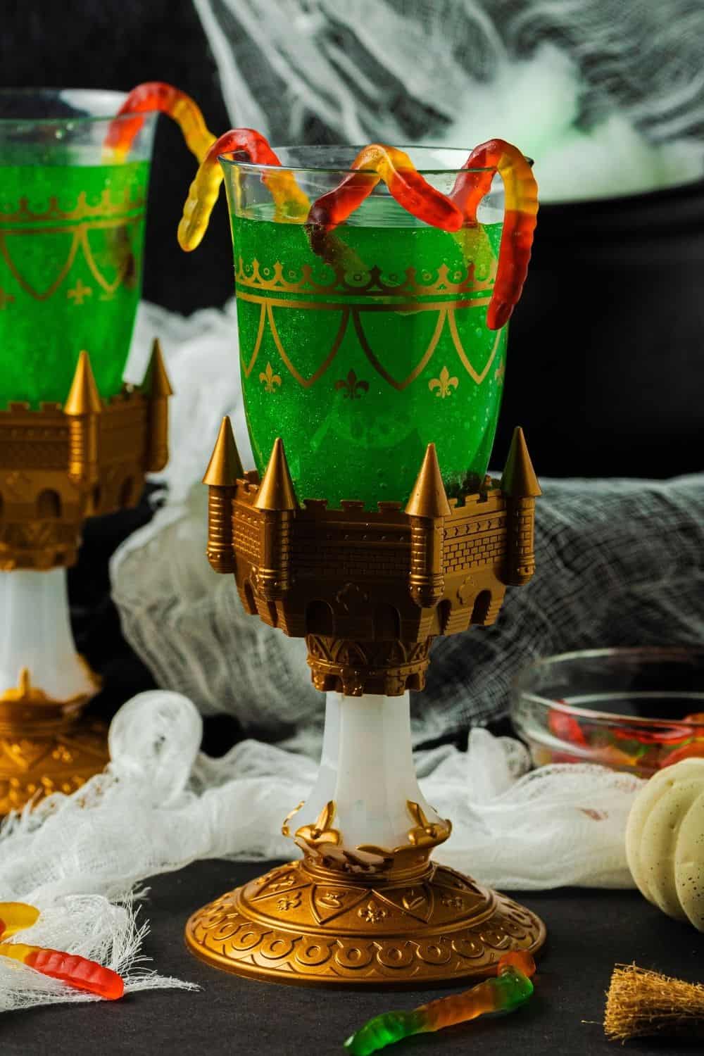 Non-alcoholic Beetlejuice punch, AKA witches' brew punch or Hocus Pocus punch, served in two glasses with gummy worms candy.