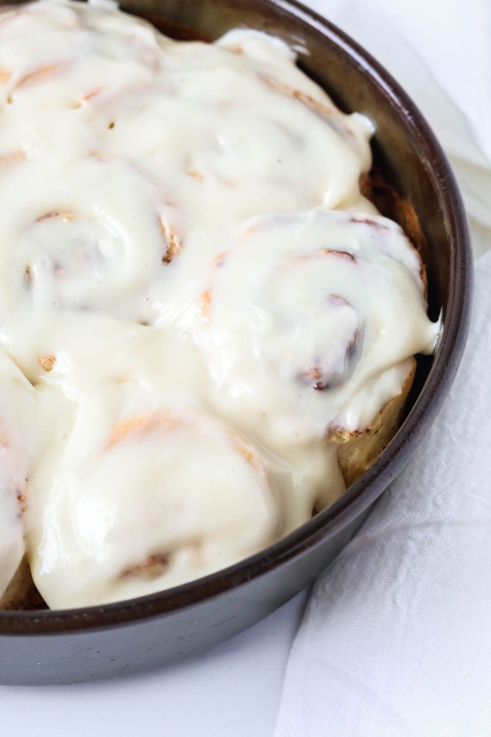 close-up view of a pan of cinnamon rolls made with Bisquick, topped with vanilla icing.