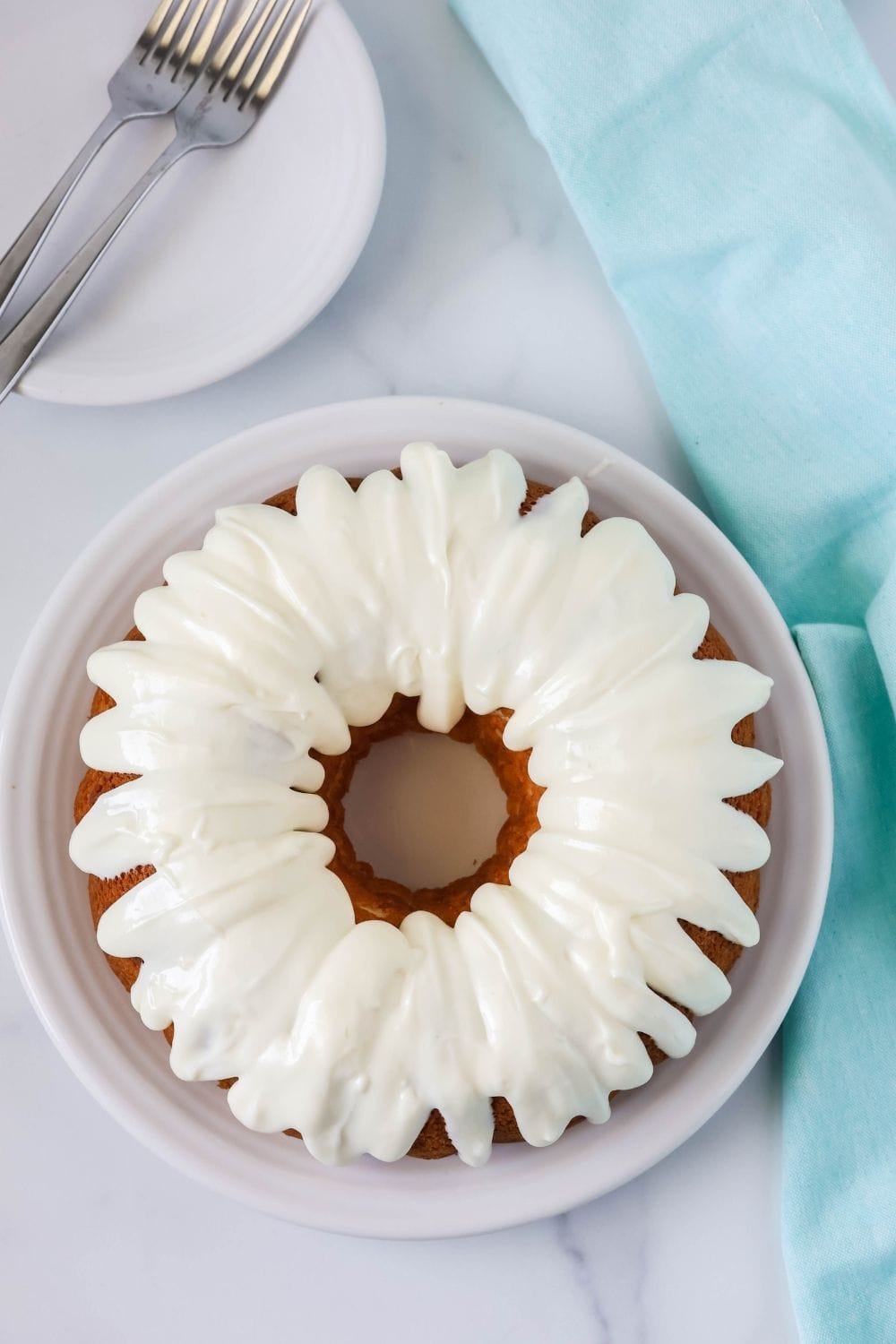 overhead view of a bundt cake made with white cake mix and topped with cream cheese icing.