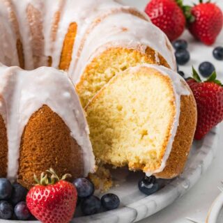 Vanilla pudding pound cake served on a marble platter, with fresh berries.