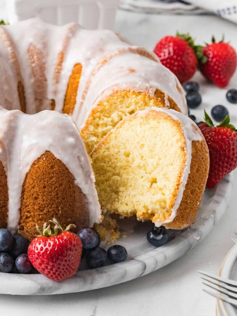 Vanilla pudding pound cake served on a marble platter, with fresh berries.