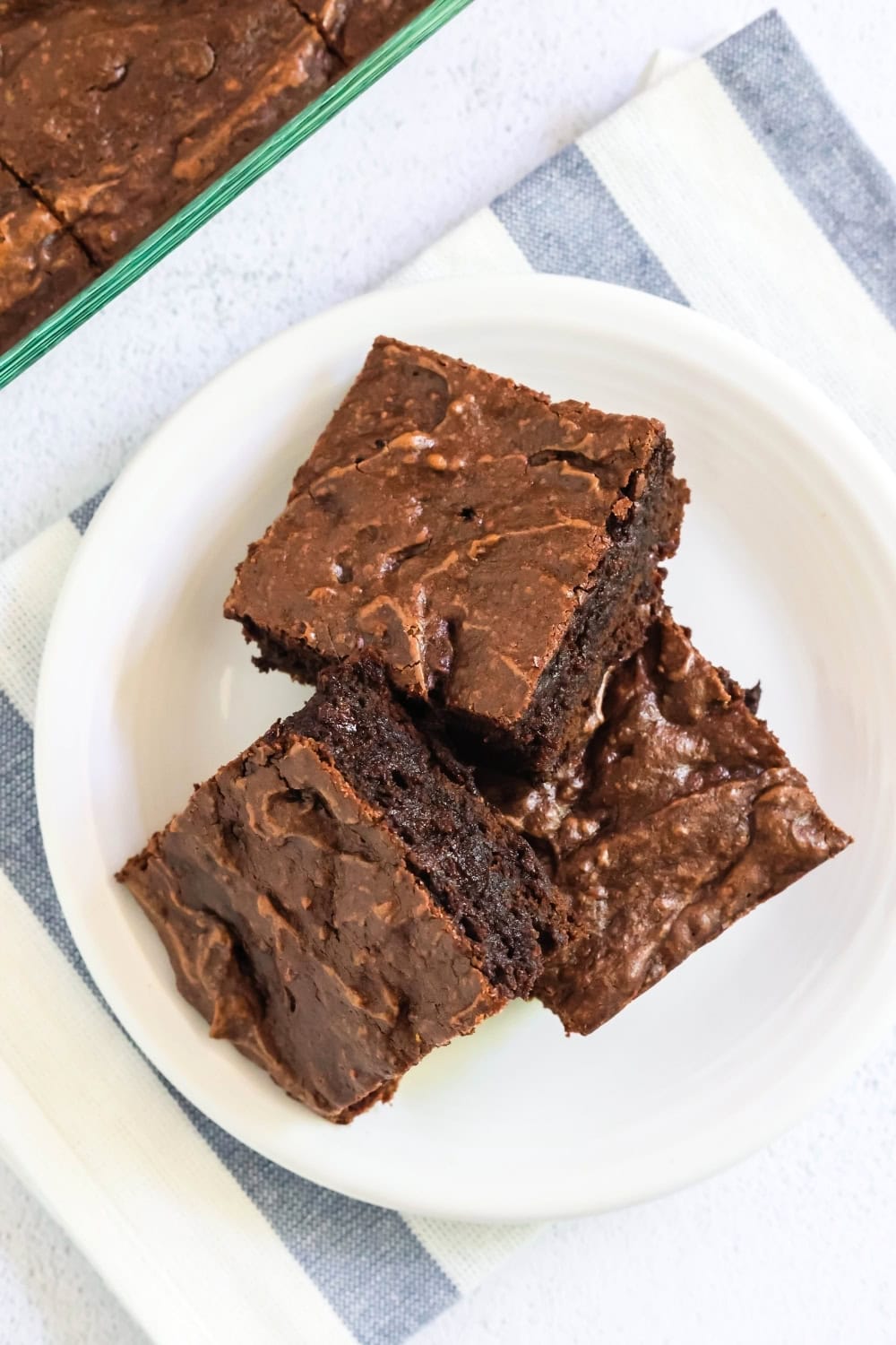 overhead view of three chocolate pudding brownies on a white plate.