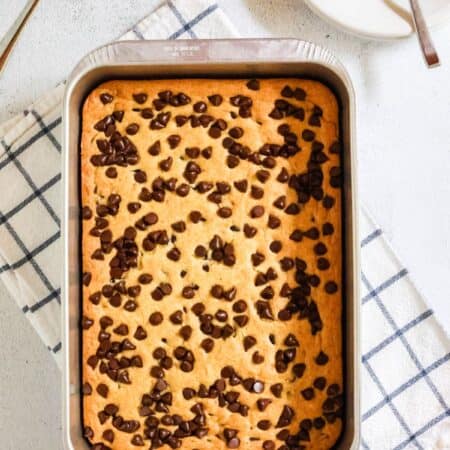 overhead view of an aluminum cake pan with vanilla pudding dump cake in it.
