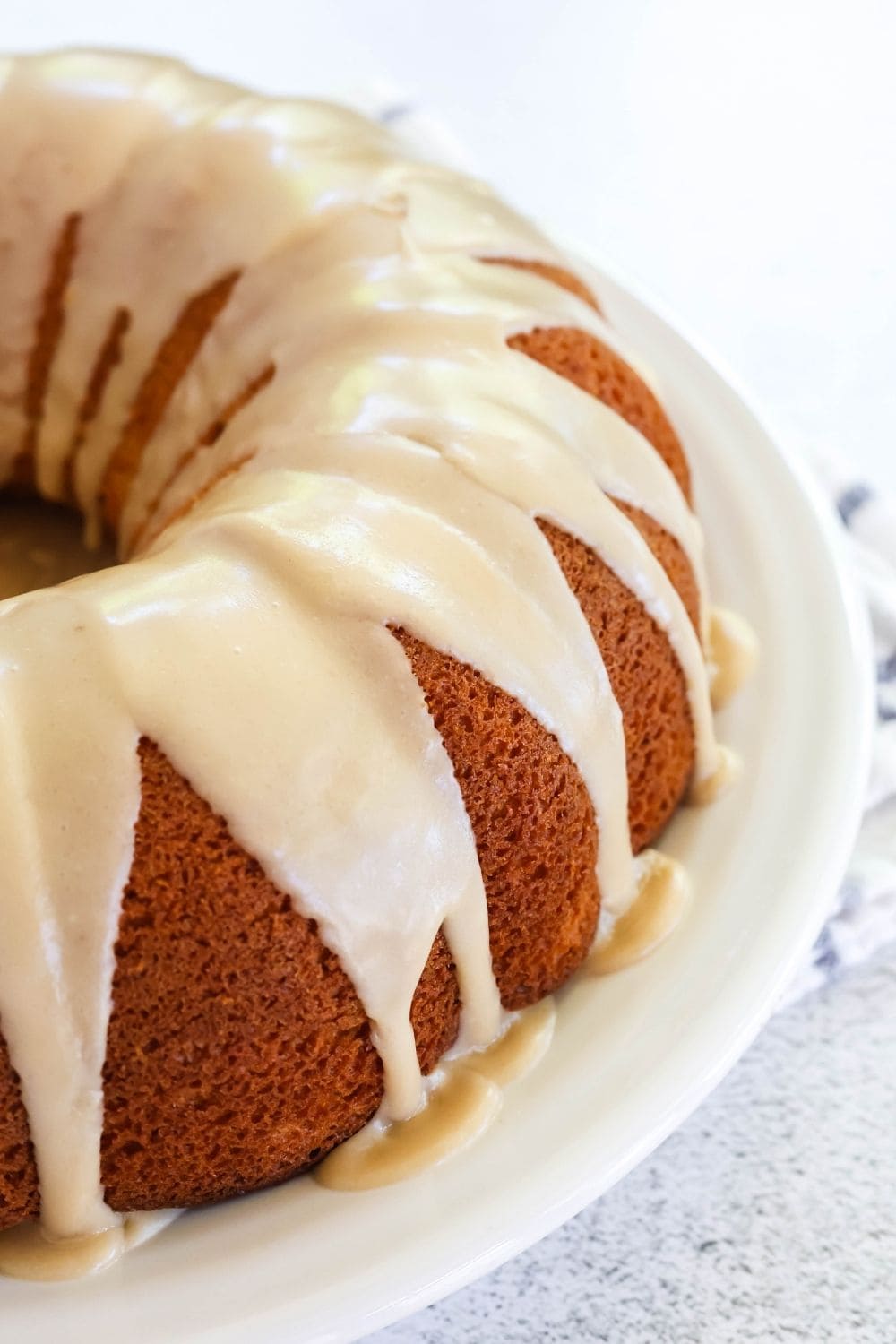 close-up side view of a peach cake made with a box of cake mix. The cake is drizzled with brown sugar icing.