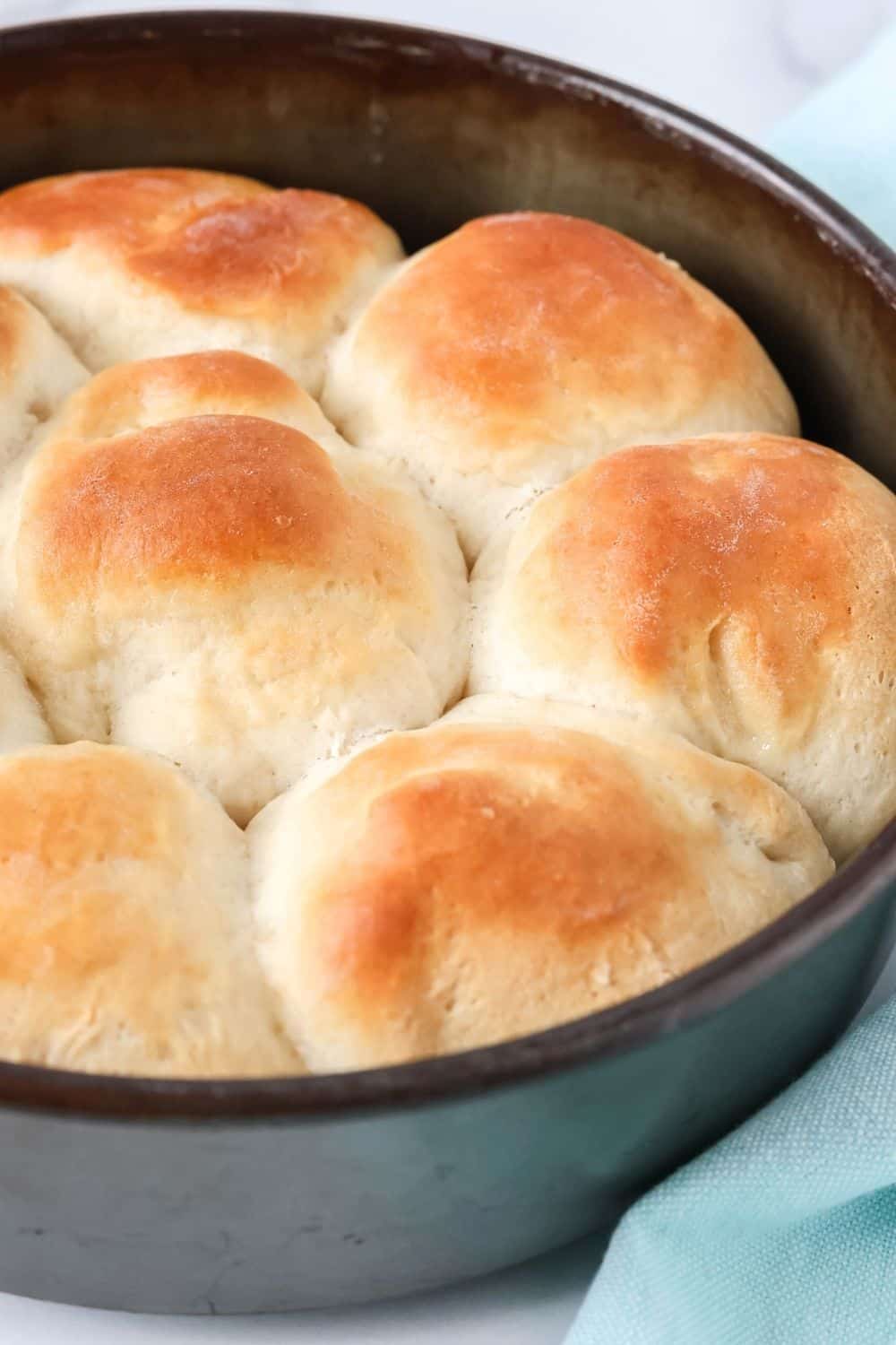 close-up view of a round cake pan filled with freshly baked, golden-brown yeast rolls made with Bisquick.