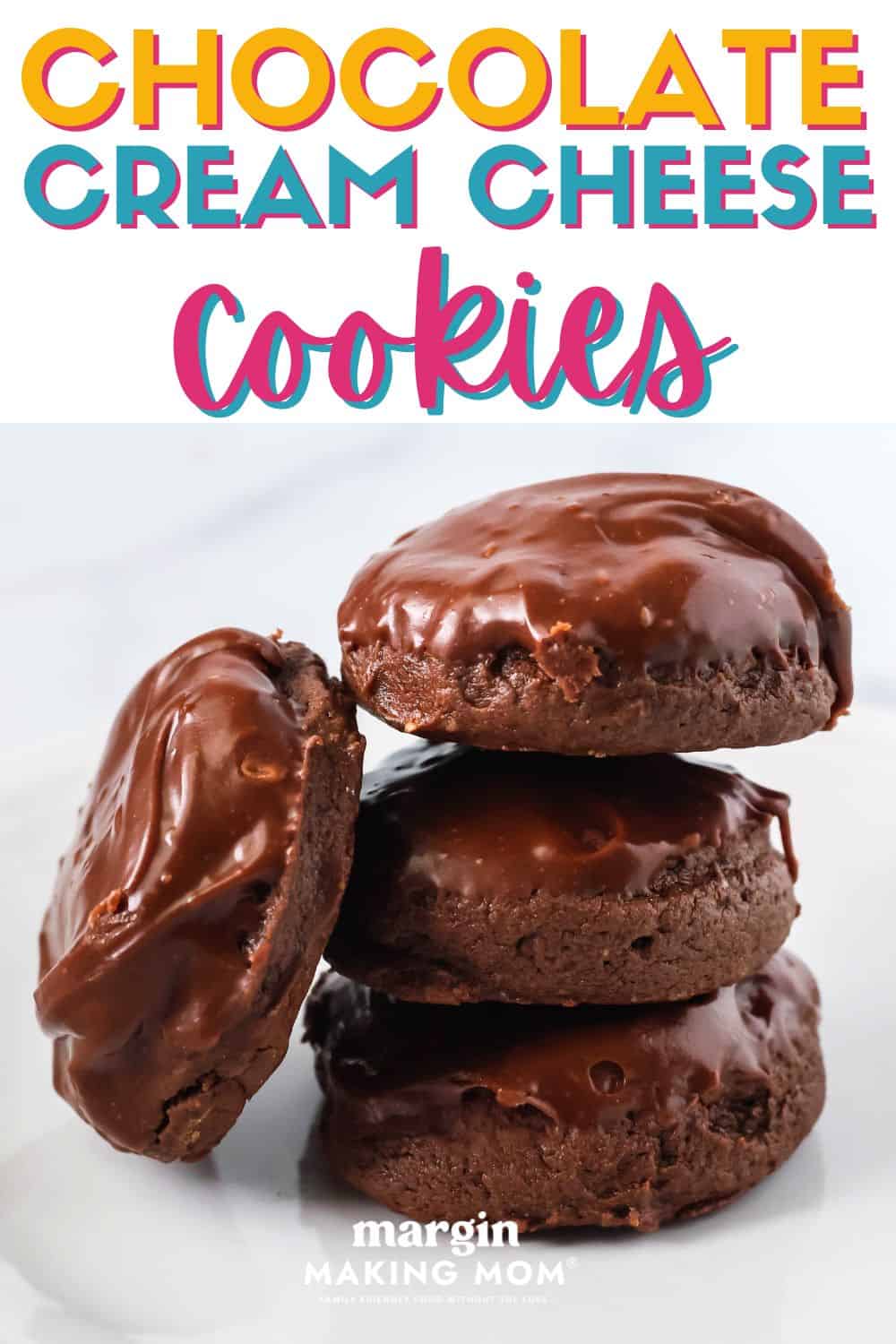 four chocolate cream cheese cookies on a white plate; three are stacked and the fourth is leaning against the stack.