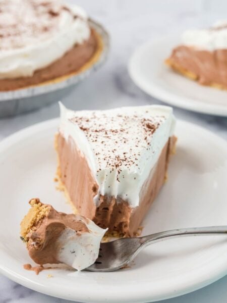 A slice of chocolate Dream Whip pie with a bite removed from the tip of it by a fork.