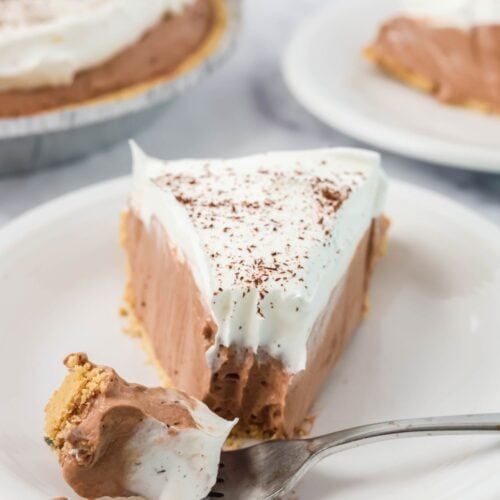 A slice of chocolate Dream Whip pie with a bite removed from the tip of it by a fork.