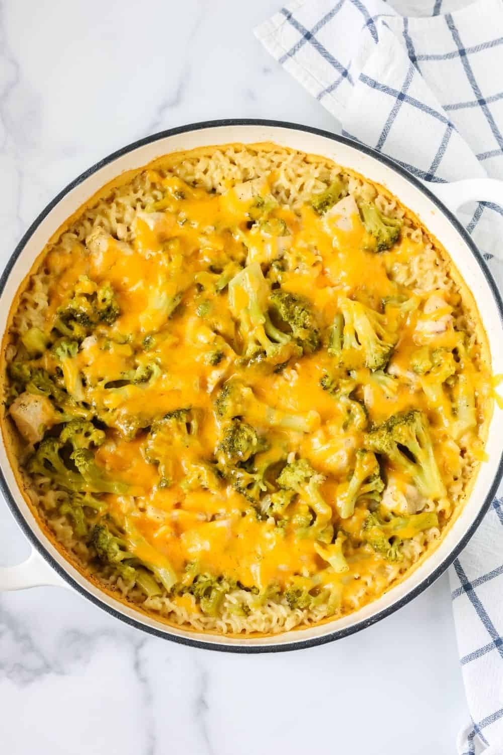 overhead view of a enameled cast iron dutch oven dish filled with homemade cheesy chicken broccoli rice casserole.