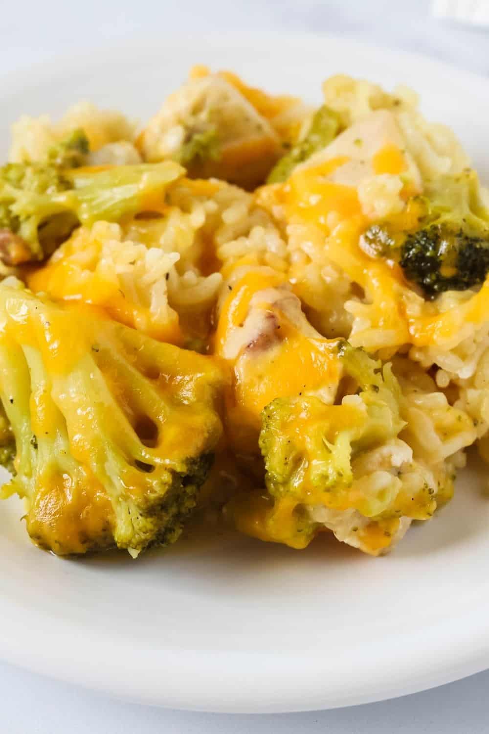close-up view of southern-style broccoli, rice, chicken, and cheese casserole served on a white plate.