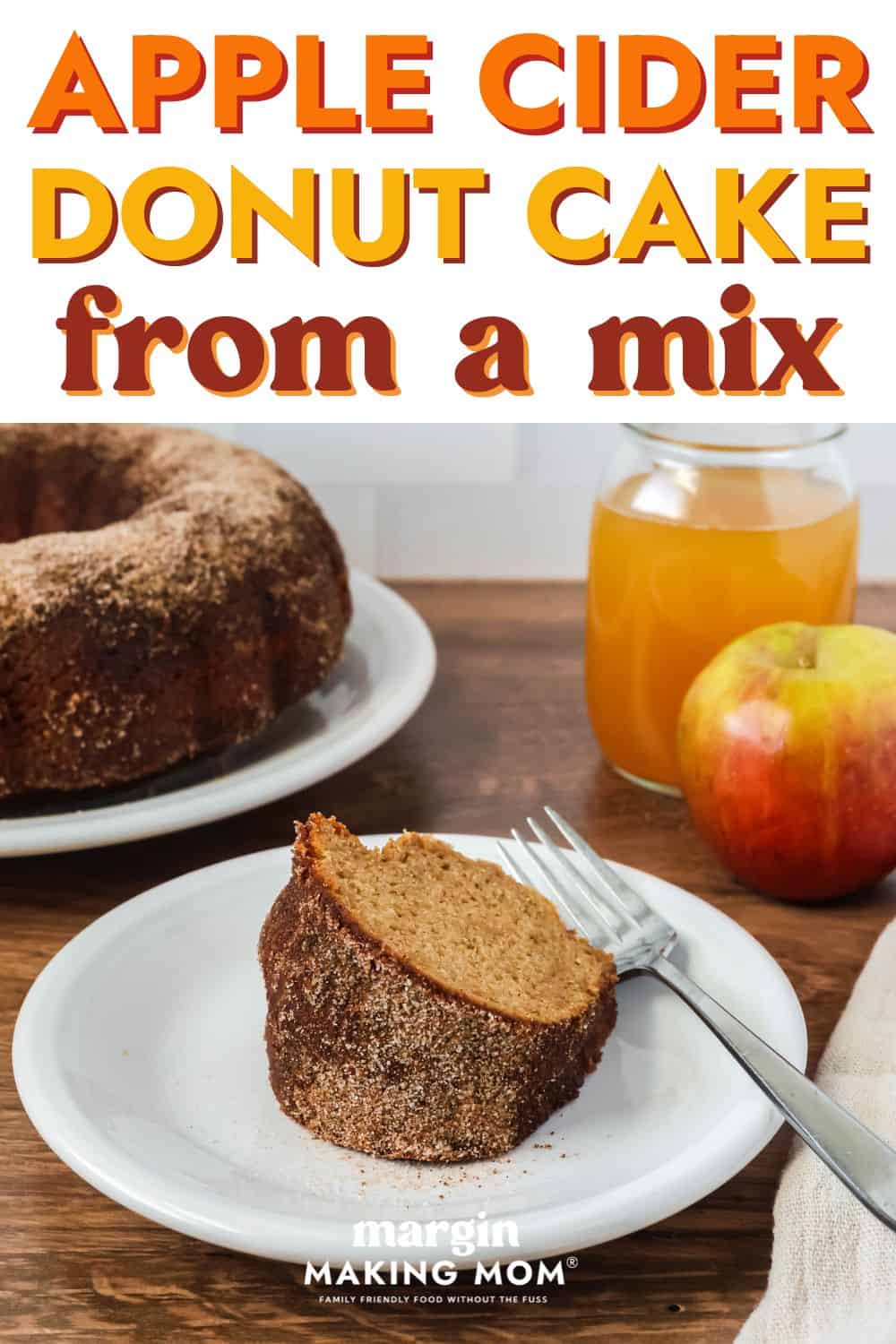 a slice of apple cider donut cake served on a white plate with a fork, showing its cinnamon sugar coating.